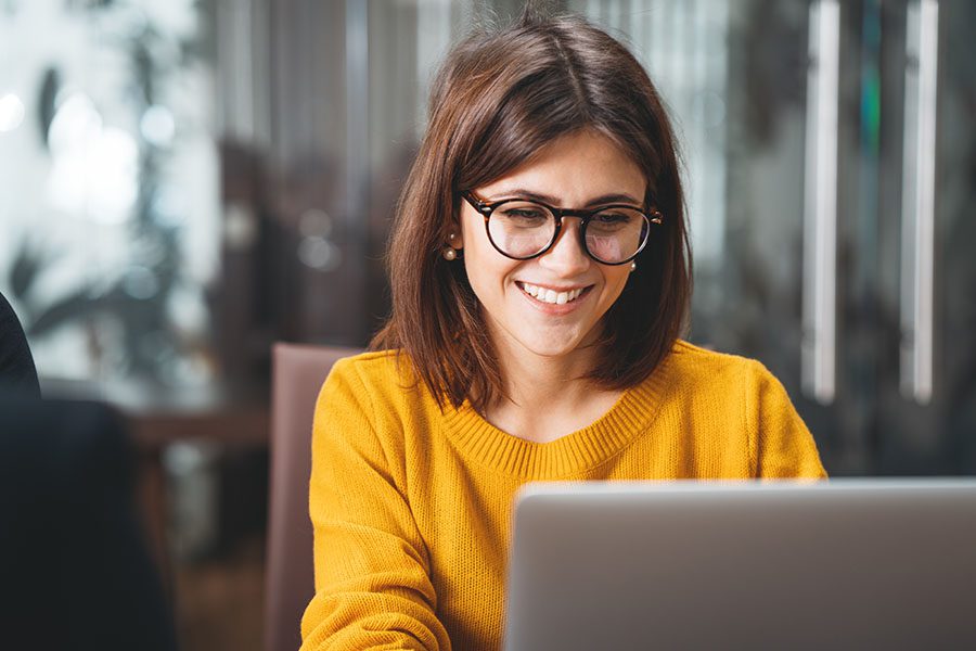 Client Center - Woman with Glasses Working at Her Laptop in Her Home Office